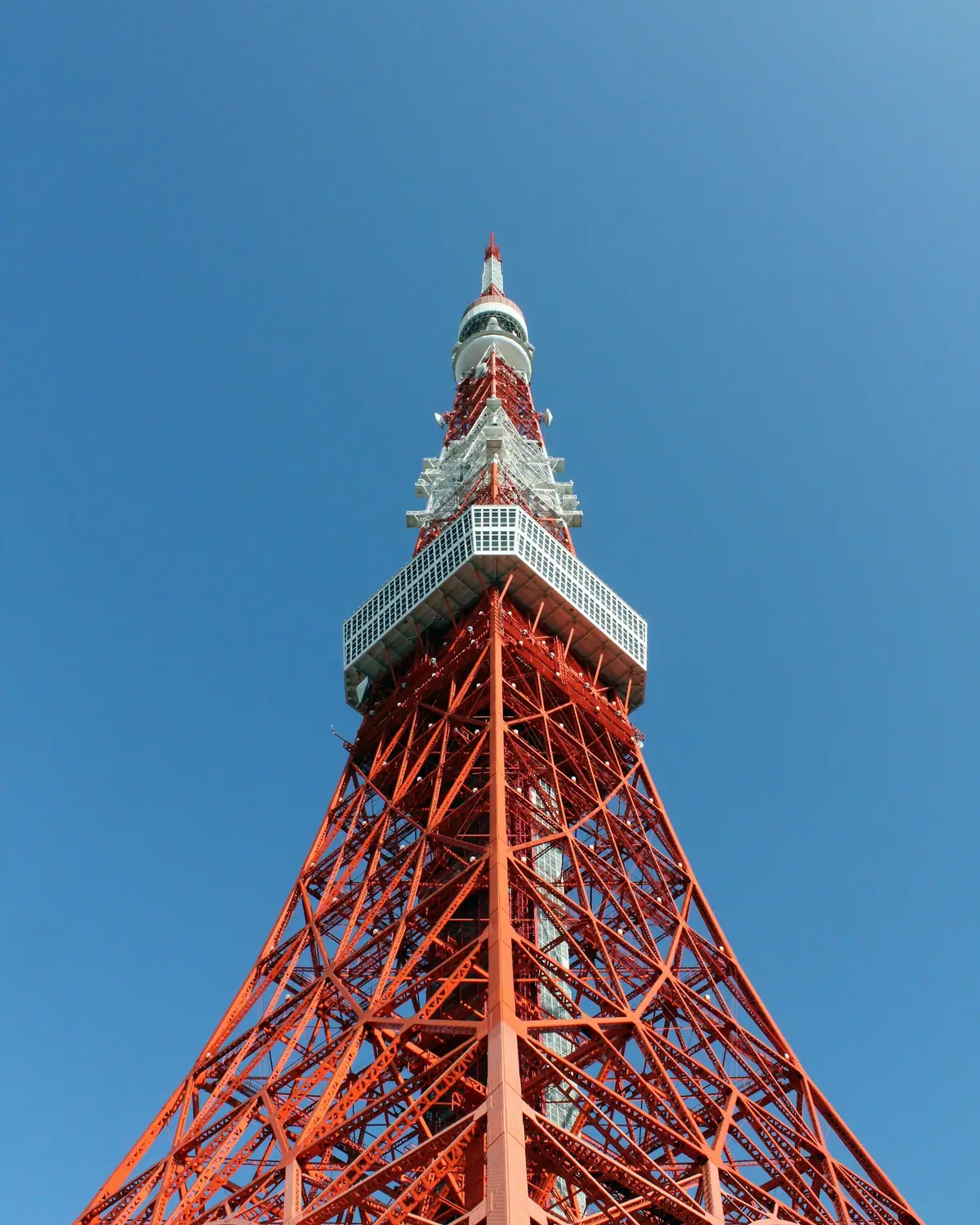 الهيكل الفولاذي الأحمر والأبيض لـ Tokyo Tower أمام سماء زرقاء