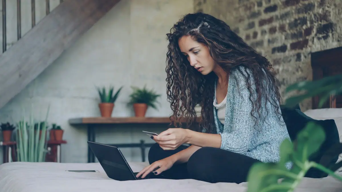 Hände, die eine Kreditkarte für eine Online-Zahlung auf einem Laptop verwenden