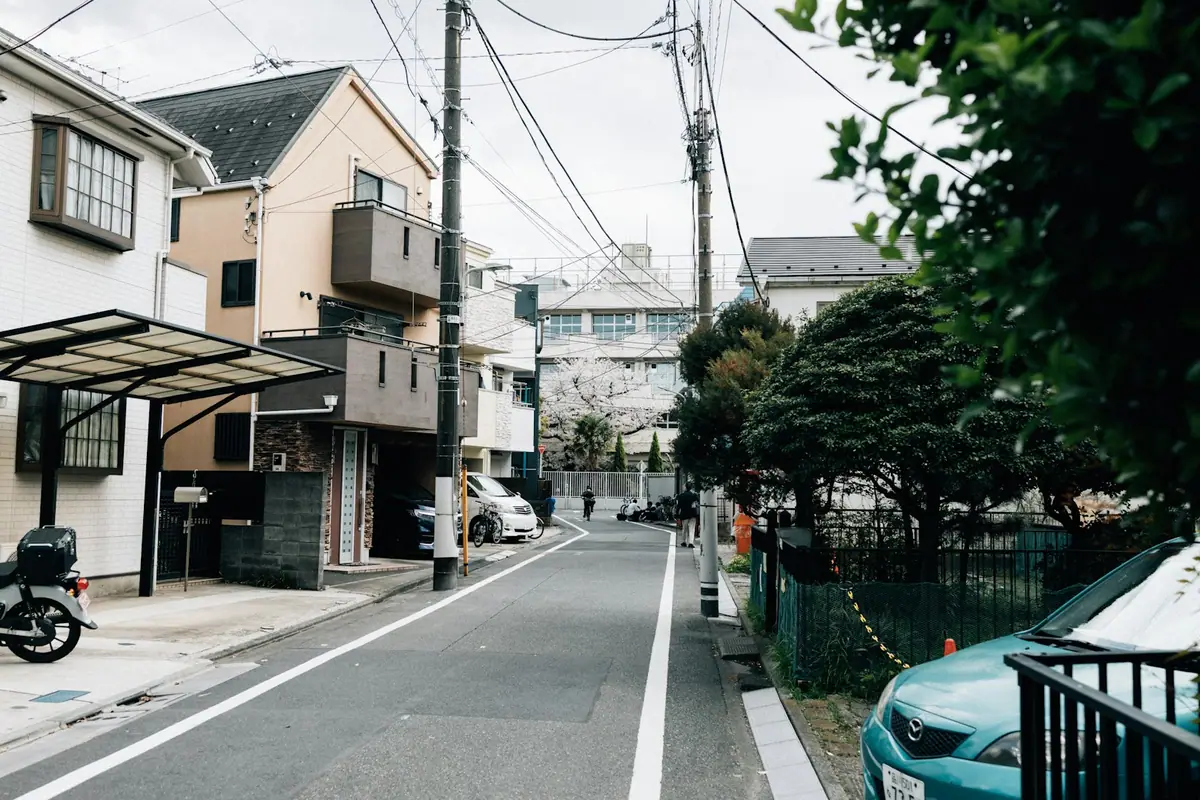 O stradă rezidențială liniștită din Tokyo cu copaci de cireș de-a lungul drumului